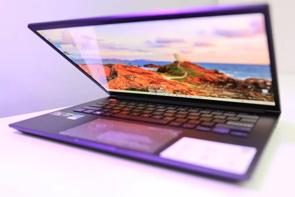 Side view of a sleek laptop displaying a scenic wallpaper with a colorful horizon.