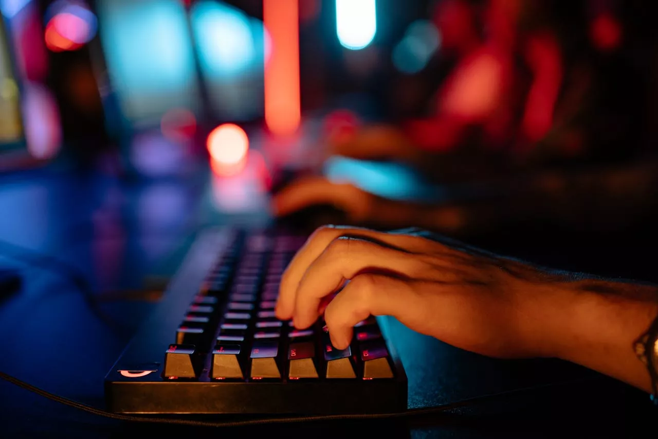 about-img Fingers typing on an illuminated keyboard in a dimly lit room, creating a tech-focused atmosphere.