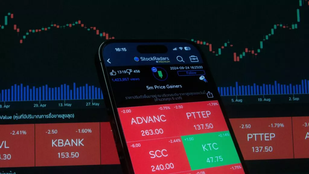 pexels-photo-28682356-28682356 Mobile screen displaying stock market analysis with financial charts in the background.